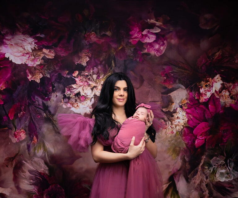mom holding a newborn wearing pink during a newborn photoshoot