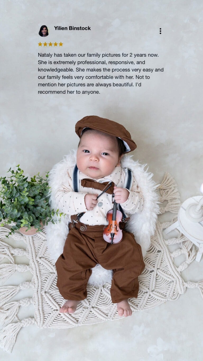 Baby boy in vintage outfit with violin prop during newborn photo session - client testimonial overlay