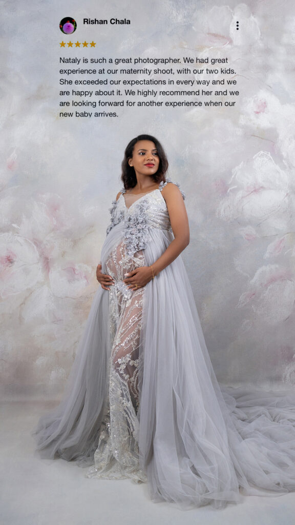 Mother in silver maternity gown poses against floral backdrop &ndash; client review overlay