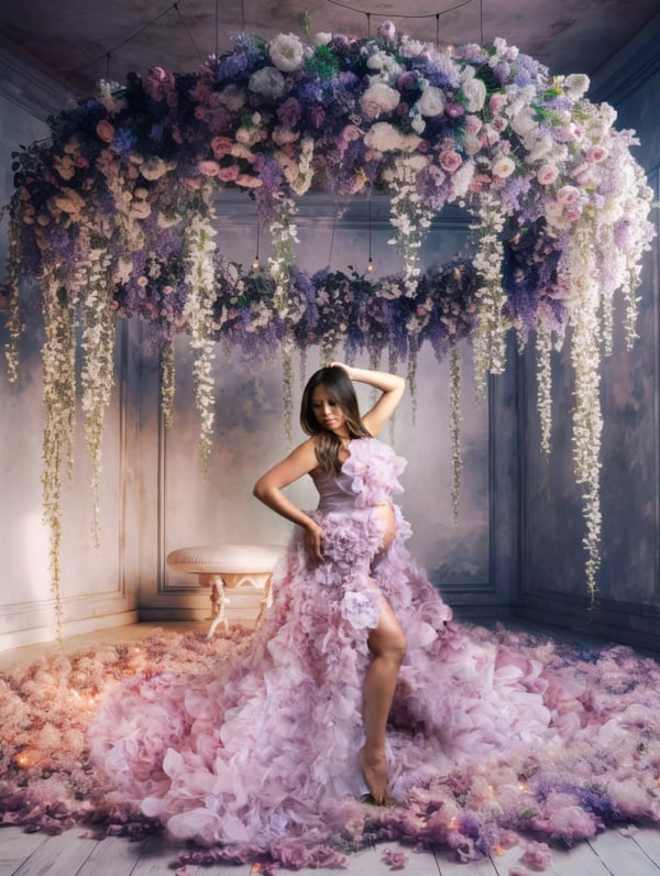 Maternity in Bloom — Floral Dream Portrait Pregnant woman in a pink floral maternity gown posing in a fantasy-inspired floral studio setting