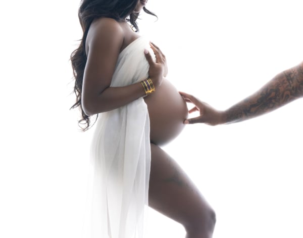 Touch of Love — Intimate Maternity Moment Side view of a pregnant woman draped in white fabric