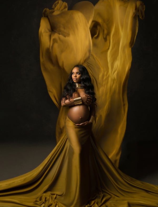 Golden Elegance — Maternity Portrait in Flowing Fabric Elegant maternity photo of a pregnant woman wrapped in golden fabric