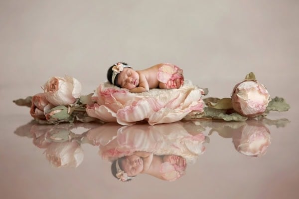 Newborn baby girl sleeping in a pink peony flower with floral headband, artistic newborn photography by Washington DC photographer.