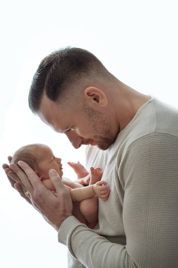 Father holding newborn baby close, foreheads touching, in natural light &mdash; Washington DC baby photography.