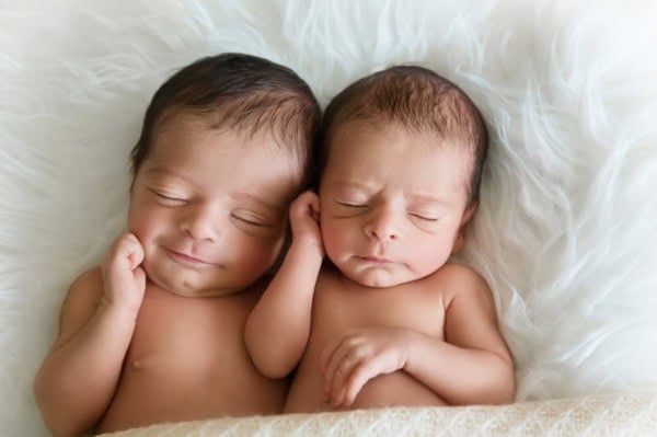 Twin newborn babies sleeping peacefully on a white fur blanket &mdash; Washington DC newborn photographer.