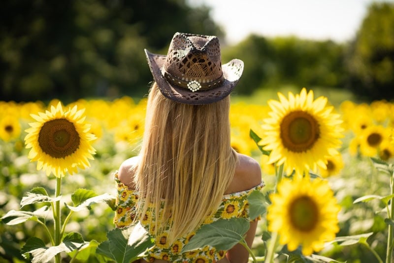 Sunflower photography session in Virginia – woman in lace gown with cowboy hat.